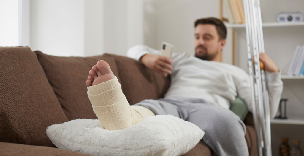 Patiente en convalescence à domicile avec pied surélevé après chirurgie hallux valgus